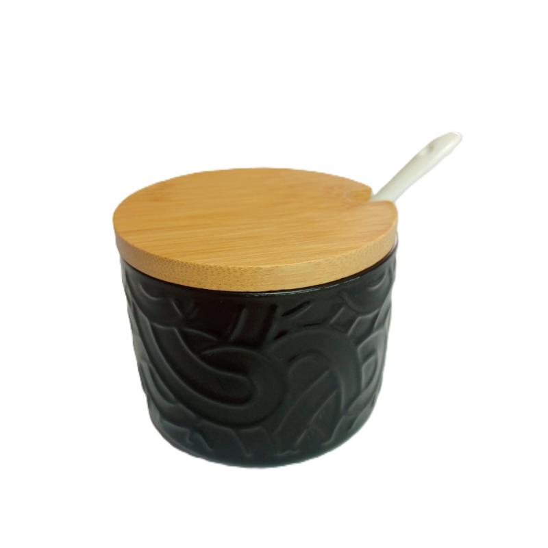 Azucarero de cerámica negro con tapa de bambú y una cuchara blanca